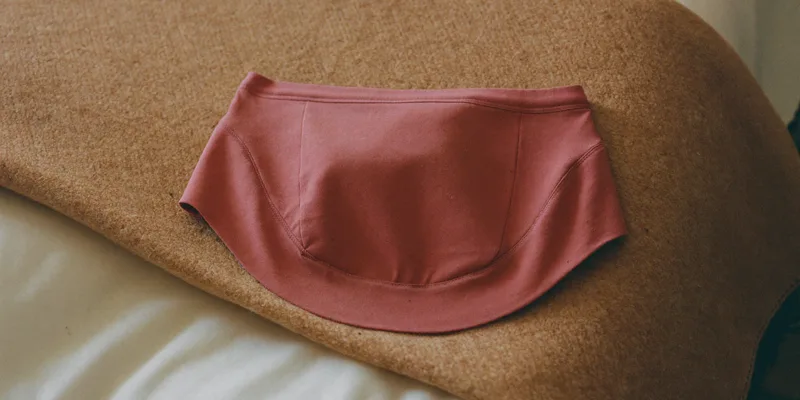Soft dusty rose maternity support band on a blanket