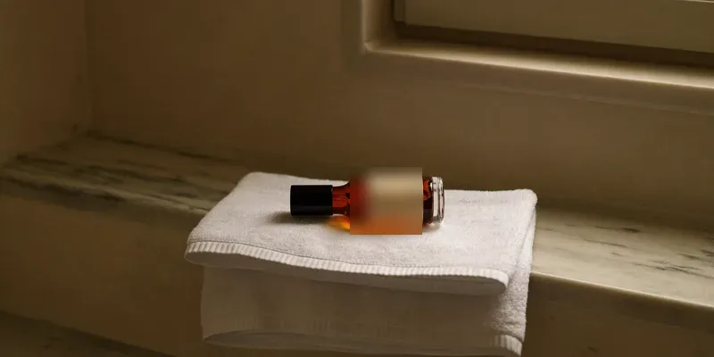 Amber glass bottle of body oil on a folded towel