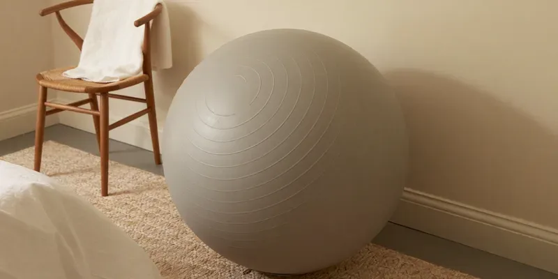 Large grey exercise ball on a rug in a bedroom