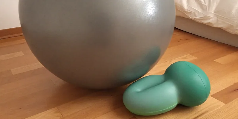 Round grey ball beside a smooth teal peanut ball