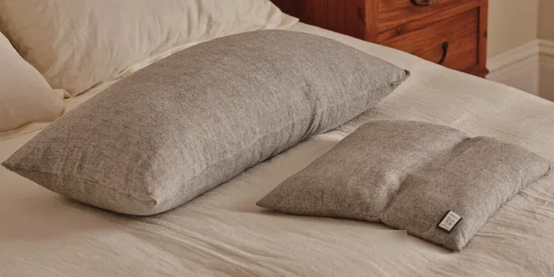 Compact side sleeper pillow and wedge on cream bedding