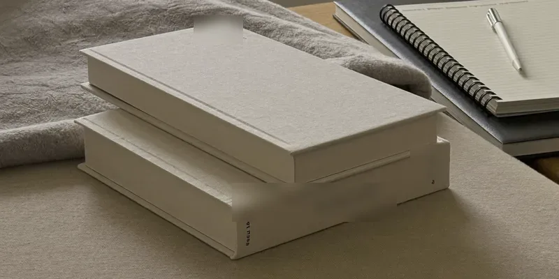 Two plain books and a notebook on a low table