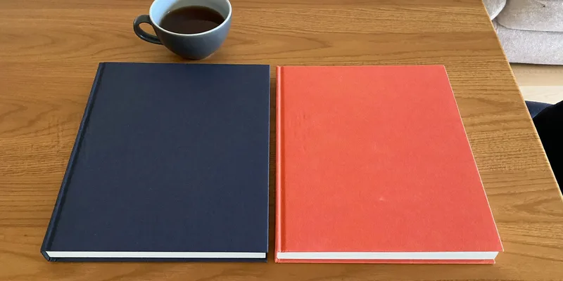 Navy and coral books side by side with coffee