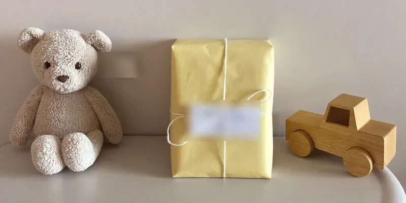 Yellow wrapped gift with toy truck and teddy bear