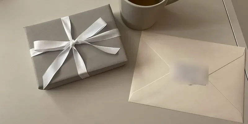 Small grey wrapped gift with envelope and tea