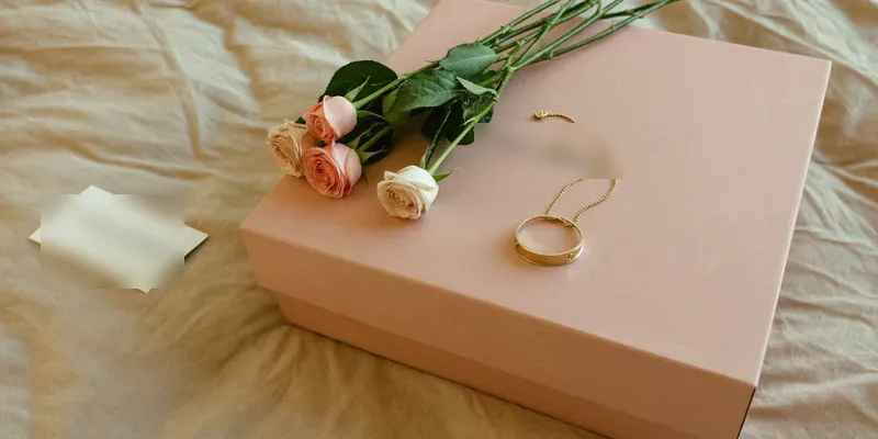 Blush wrapped gift with a gold bracelet and roses