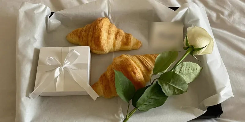 Breakfast tray with a gift and a single rose