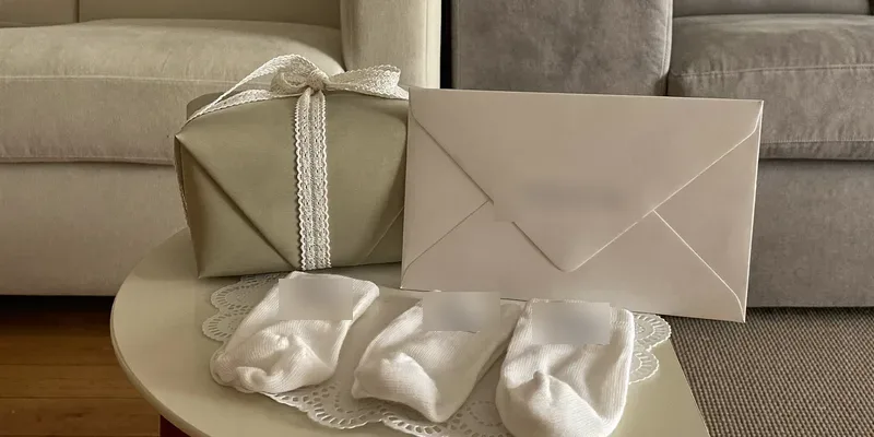 Sage wrapped gift with baby socks and envelope