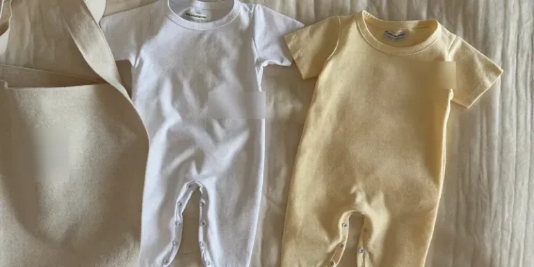 Two identical plain newborn outfits side by side