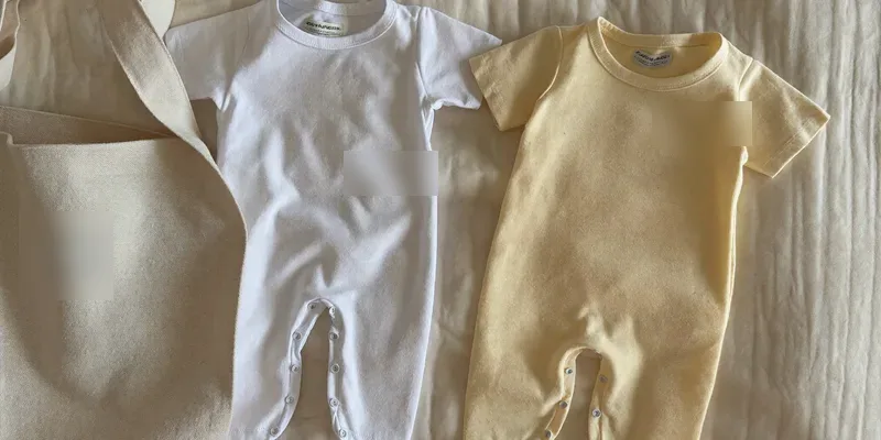 Two identical plain newborn outfits side by side