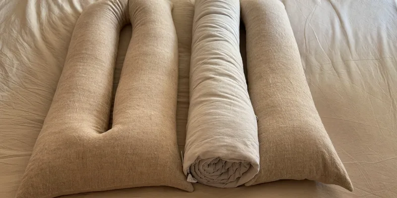 U-shaped pregnancy pillow wrapped around a rolled duvet