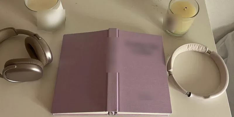 Lavender book with headphones and a candle