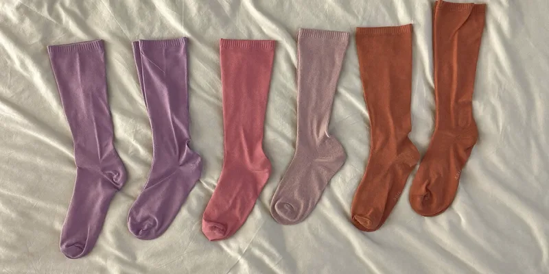 Three pairs of knee high socks in soft colors