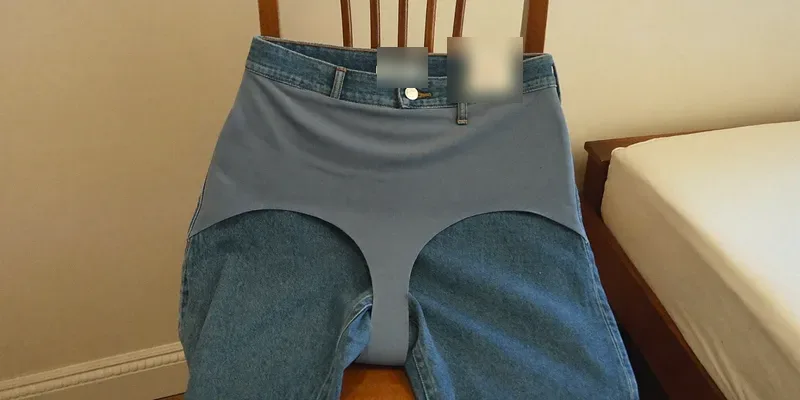 Jeans with elastic stretch panel over a chair back