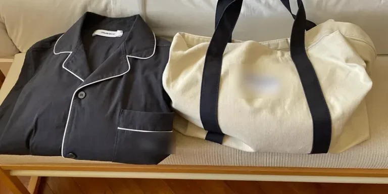 Navy pajama set beside a packed overnight bag