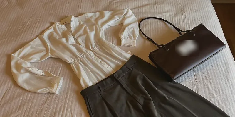 White blouse and trousers with a leather tote bag