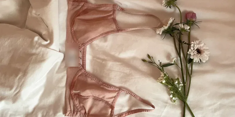 Delicate soft bralette laid flat on white bedding