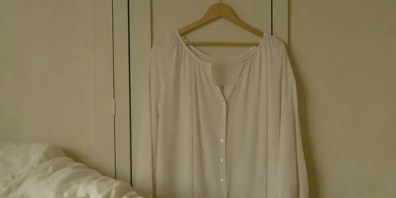 Cream nightgown with front buttons on a hanger