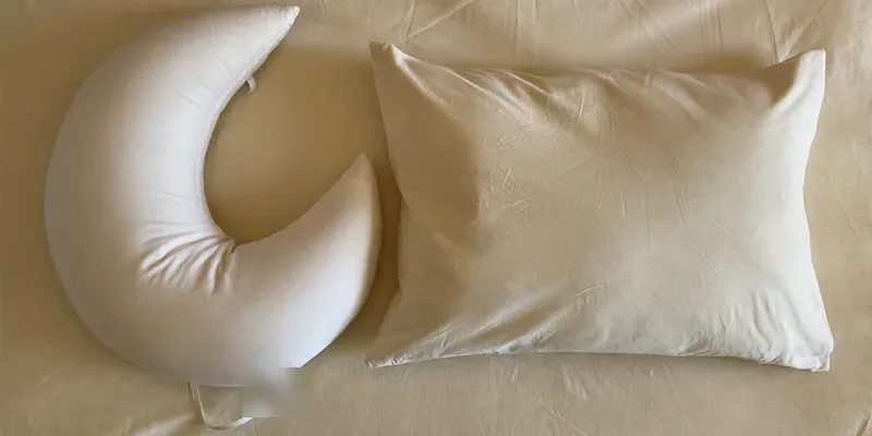 Crescent nursing pillow beside a rectangular pillow