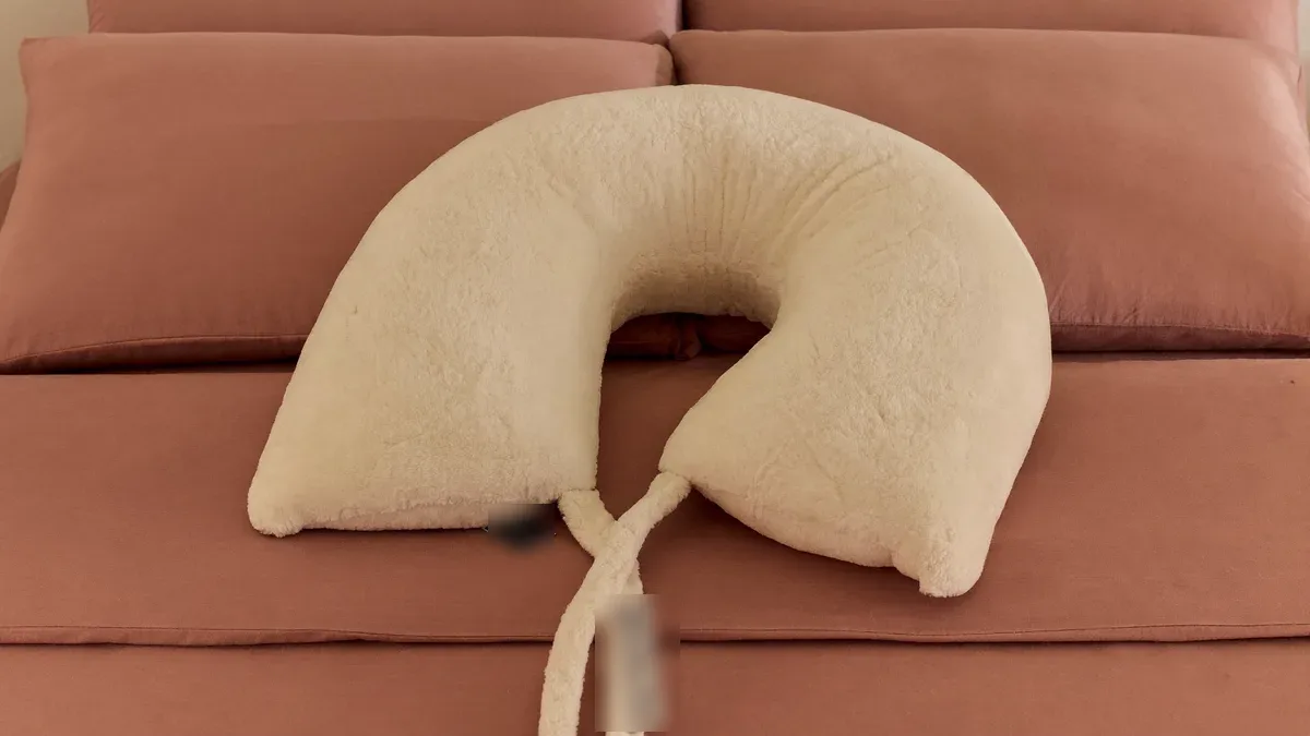 U-shaped pregnancy pillow on a neatly made bed