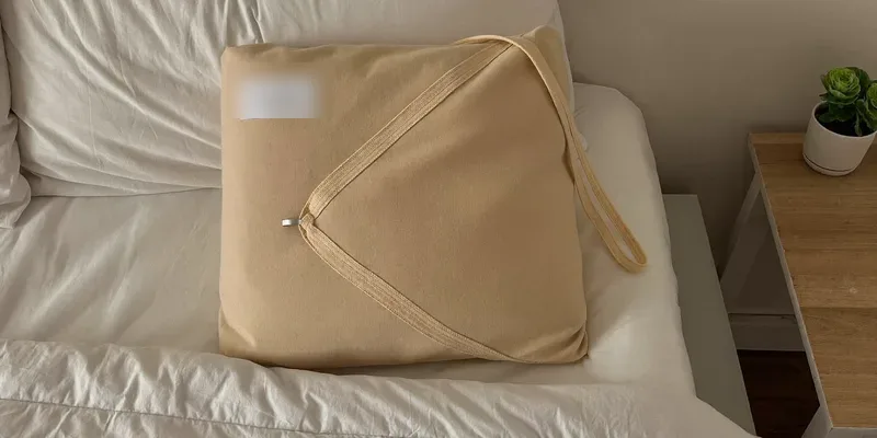 Wide beige belly wrap folded on white bedding
