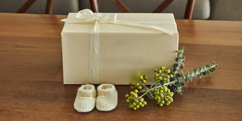 Ivory wrapped gift with tiny knitted baby booties