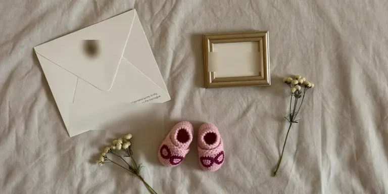 Flat lay with baby shoes, envelope and empty frame