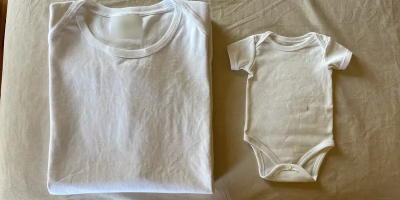 Adult t-shirt beside a tiny baby onesie