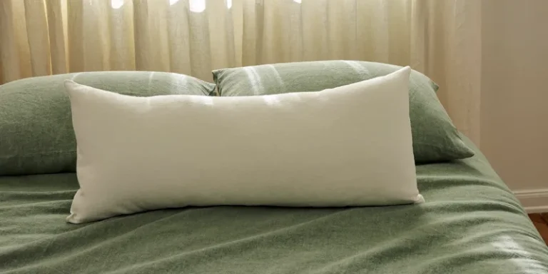 Long full body pillow lying diagonally on sage bedding