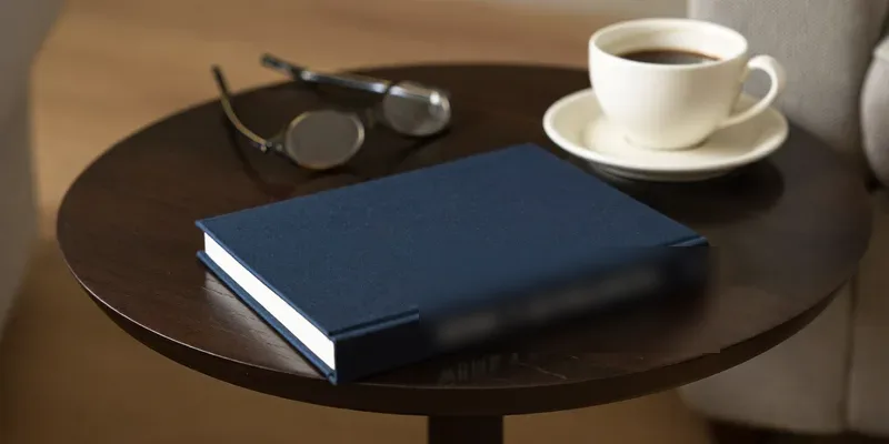 Navy book with coffee and glasses on a side table