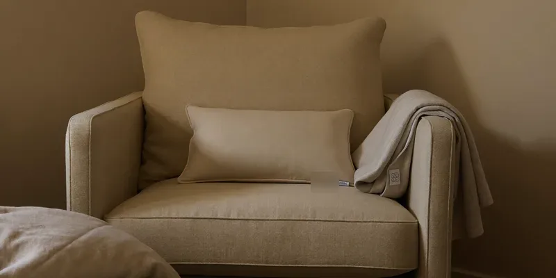 Armchair layered with soft support pillows and a blanket