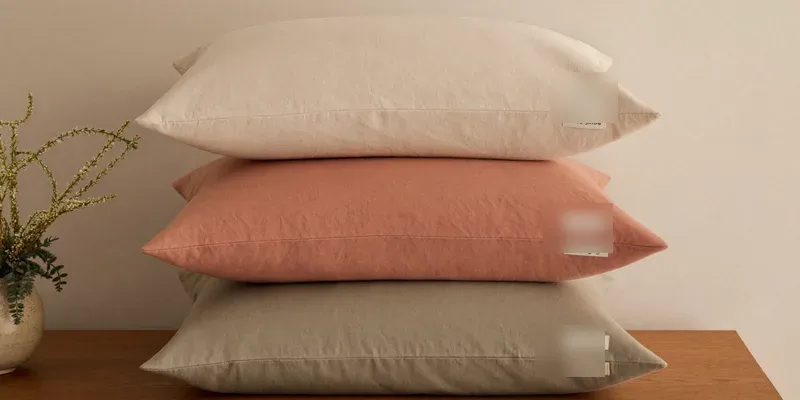 Stack of folded pillow covers in soft colors