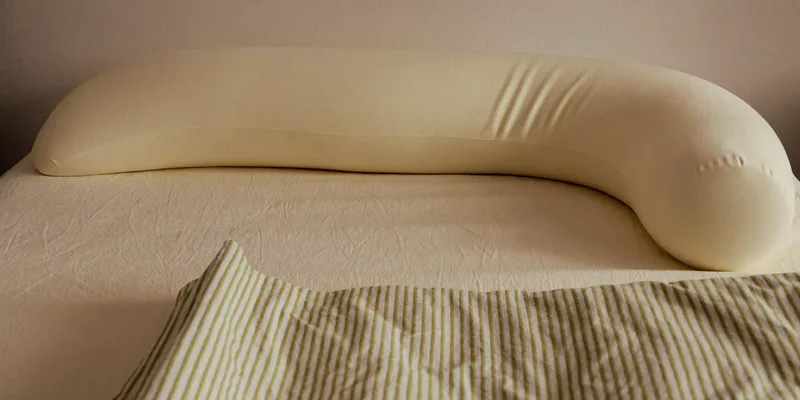 Curved pregnancy pillow arranged for side sleeping