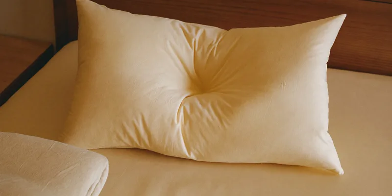 Low flat wedge pillow with hollow center on cream bedding