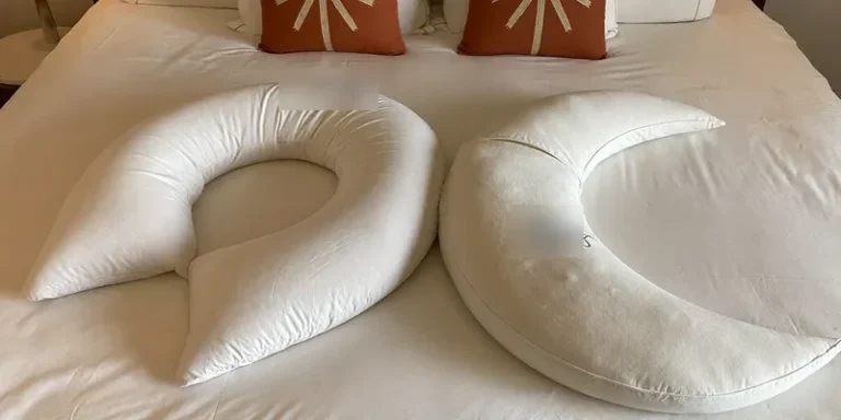U-shaped and C-shaped pregnancy pillows compared on a bed