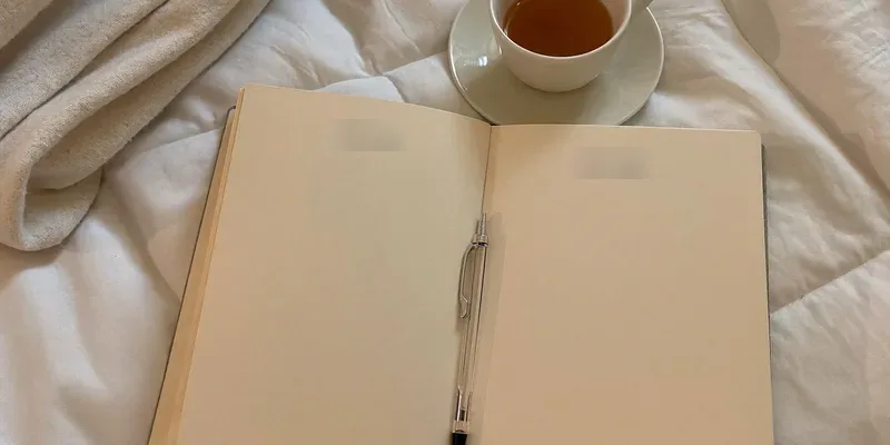 Open journal with blank pages and a pen